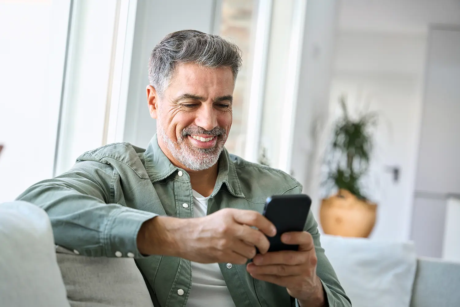Mit Transaktionsmails den E-Commerce-Erfolg steigern. Ein Kunde kauft zufrieden auf dem Handy im Internet ein.