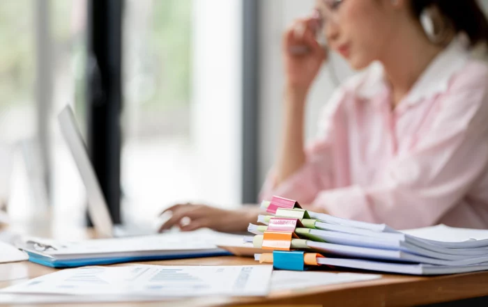 Digitalisierung in der Verwaltung - Frau mit ausgedruckten Dokumenten am Computer